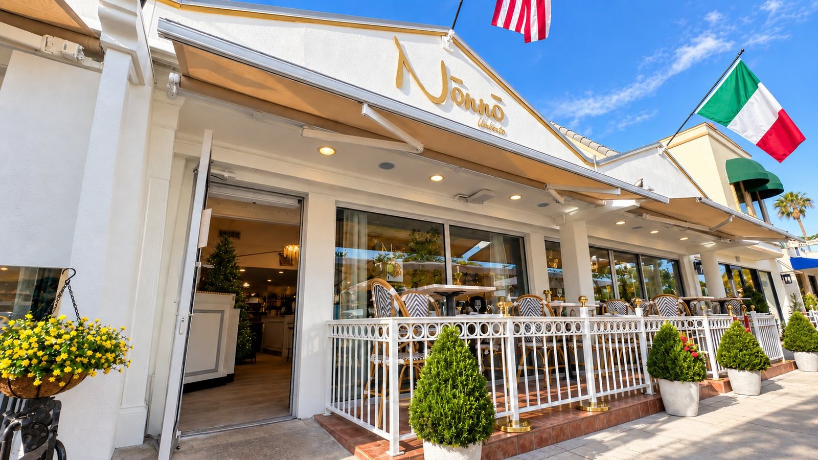 The white façade of Nōnnō Umberto on St. Armands Circle, with the gold Nōnnō Umberto sign, an outdoor terrace and an Italian flag.